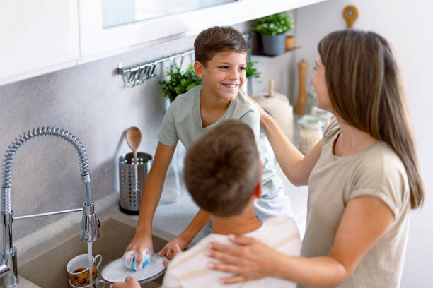 istock Mother and son smiling at each other, doing dishes 2167387103