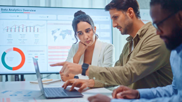 a team of multiethnic developers is meeting to discuss the data analytics of marketing. - analysera bildbanksfoton och bilder