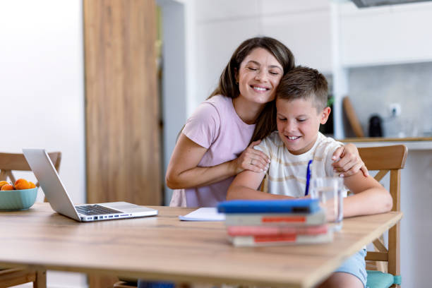 istock Woman embraces boy during homework at kitchen 2167387368