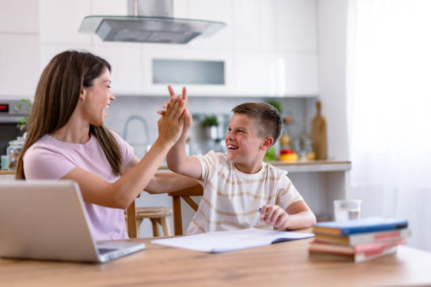 istock High-five moment between woman and boy at kitchen 2167387430