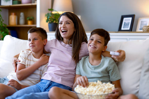 istock Mother and sons enjoying popcorn while watching a comedy. 2167387575