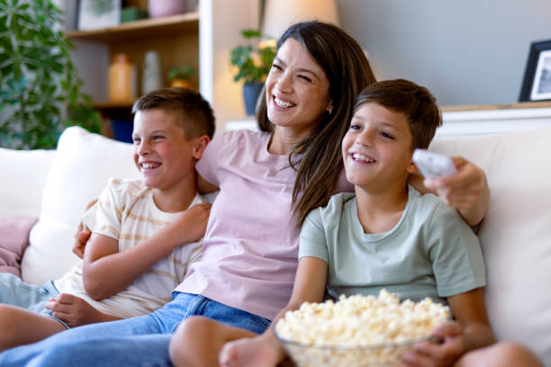 istock Smiling family enjoying popcorn on comfortable couch. 2167387596