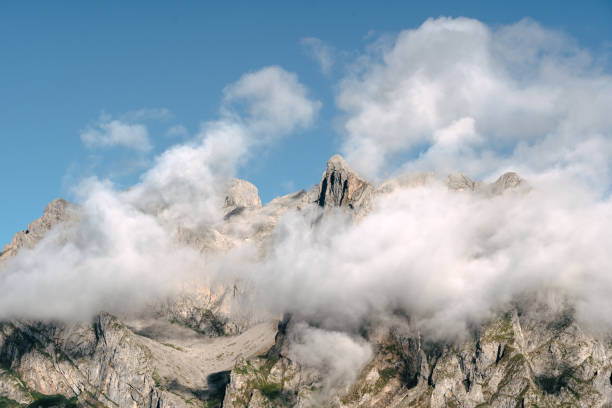 istock Mountains partially covered by clouds under a clear blue sky during daylight 2167388457
