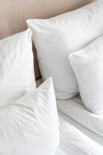 istock Crisp white bedding and pillows arranged neatly on a comfortable bed in a cozy room during daylight 2167388489