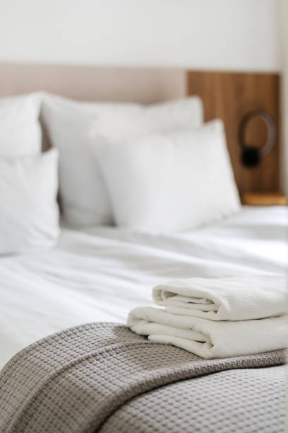 istock Cozy bedroom with neatly folded towels on a soft blanket in a serene setting 2167388490