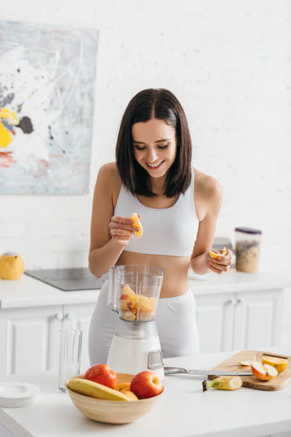 istock Young woman preparing a healthy smoothie in a bright modern kitchen 2167388665