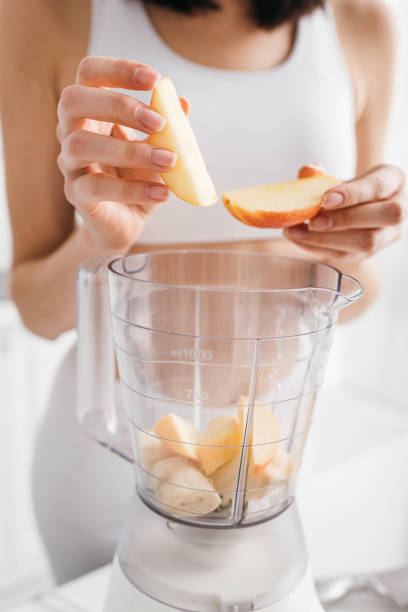 istock Young woman in activewear prepares a fresh smoothie in a bright modern kitchen 2167388765