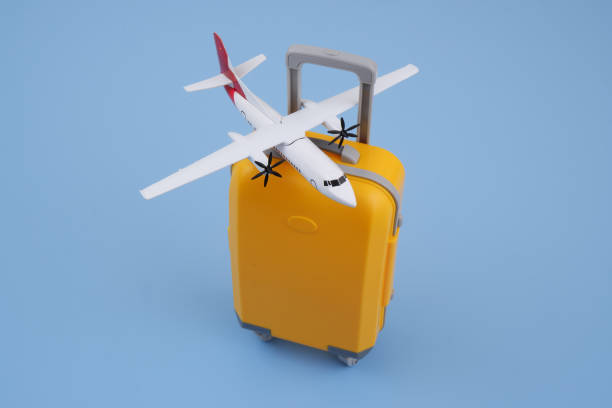 istock Airplane model on orange travel suitcase on blue background. 2167388871