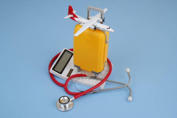 istock Airplane model and travel suitcase on calculator on blue background. 2167388880