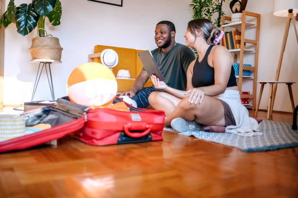 istock Young multiracial couple preparing for leaving on vacation packing suitcases 2167393142