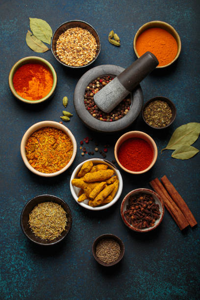 istock Mortar and pestle surrounded by colorful spices on dark background 2167394068