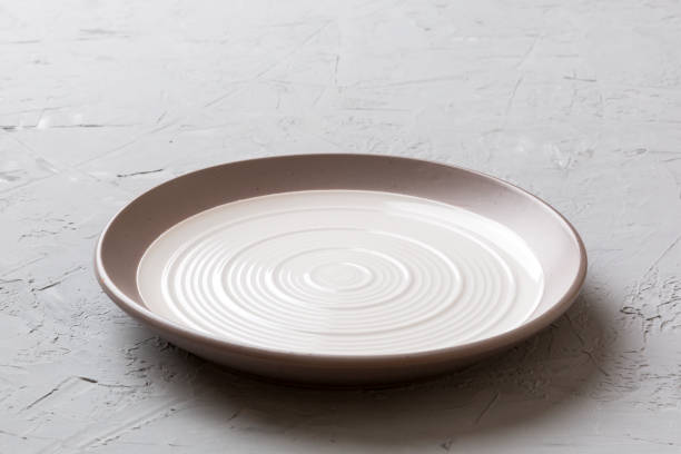 istock Perspective view of empty light plate on cement background. Empty space for your design 2167403780