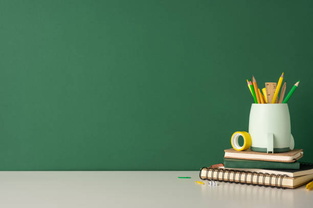 A neatly arranged desk with school supplies that include pencils, notebooks, and a pencil holder, indicating a back to school theme