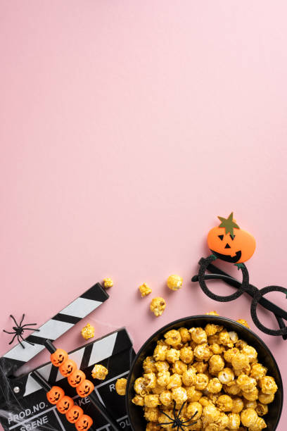 A Halloween-themed vertical setup with popcorn, film clapper, and spooky decorations perfect for a horror movie night