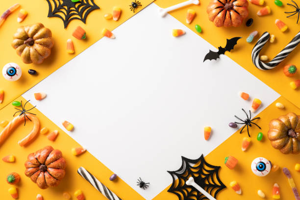 istock Creative Halloween layout featuring candy corn, pumpkins, and spooky decorations on an orange backdrop. Perfect for Halloween promotions and festive celebrations 2167406213
