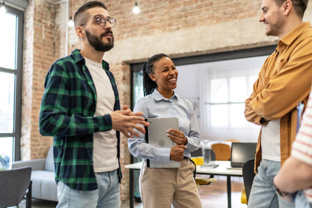 istock Young diverse colleagues, standing in the office and having a conversation 2167408390