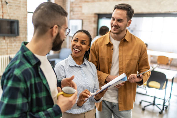 istock Three multi-ethnic coworkers standing together at an office, having a conversation. 2167410205