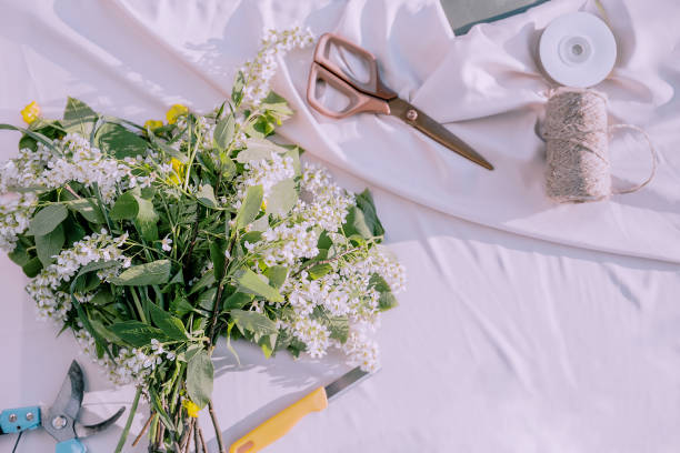 istock The florist desktop with working tools on light sunny background, Floristic tools like scissors, secateurs, twine, knife, flowers. 2167412057