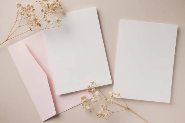 istock White blank greeting or invitation card and envelope with ceramic jar decoration on beige background. Mock up presentation. Flat lay. 2167412933