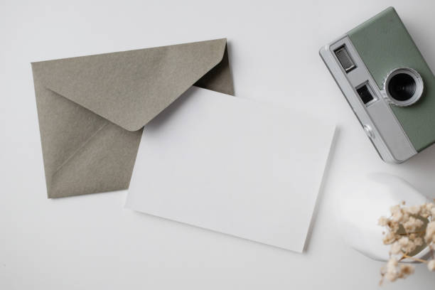 istock White blank greeting or invitation card with ceramic jar decoration and envelope on beige background. Mock up presentation. Flat lay. 2167413003