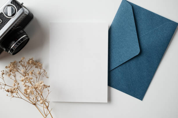 istock White blank greeting or invitation card with ceramic jar decoration and envelope on beige background. Mock up presentation. Flat lay. 2167413005
