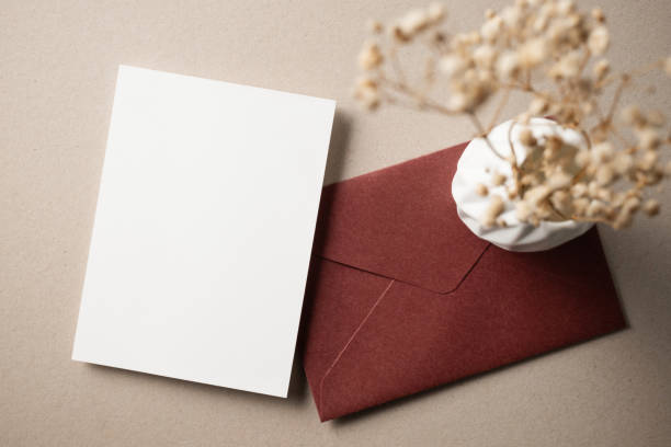 istock White blank greeting or invitation card with ceramic jar decoration and envelope on beige background. Mock up presentation. Flat lay. 2167413061
