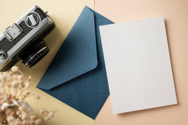 White blank greeting or invitation card with ceramic jar decoration and envelope on beige background. Mock up presentation. Flat lay.