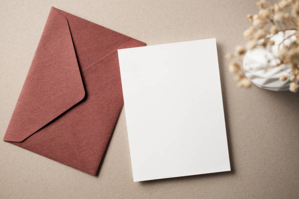 istock White blank greeting or invitation card with ceramic jar decoration and envelope on beige background. Mock up presentation. Flat lay. 2167413081