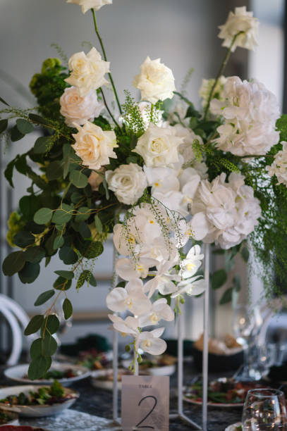 istock Table number 2. Stands, sign number two. Setup detail. Luxury reception. Elegant table decorated composition flowers in party area. Beautifully organized event. Wedding hall with atmospheric decor. 2167413936