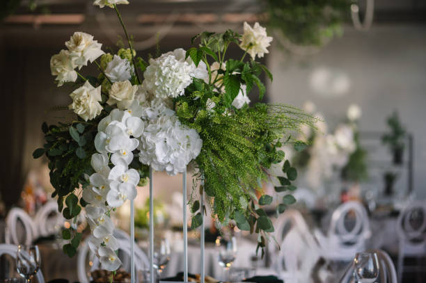 istock Flowers decor on the table closeup. Wedding set up, dinner table reception in a restaurant. Serving, setting table in hall. Glass, luxury rich decor. Birthday, baptism, event. 2167413940