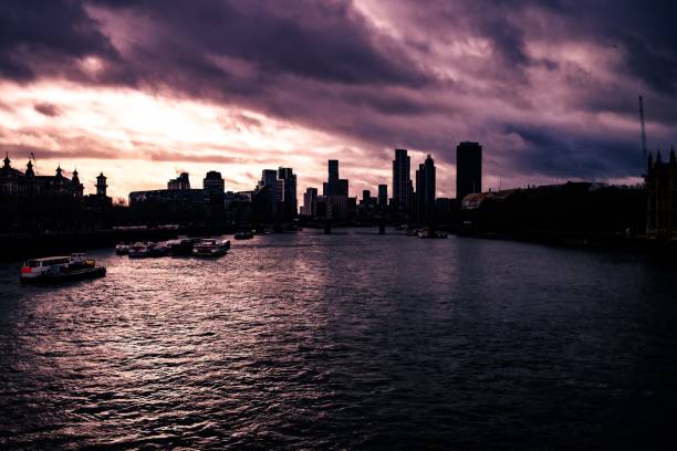 Dramatic sunset sky over the Thames River with a silhouette of the London skyline, United Kingdom.