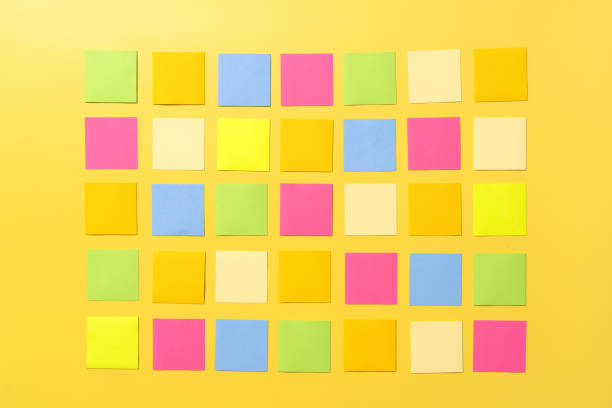 istock Many colorful empty sticky notes forming a big square on yellow background 2167420058