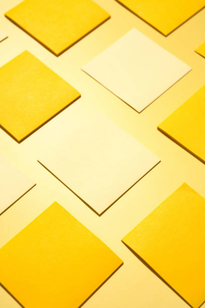 Yellow and cream squares forming a geometric pattern on yellow background Yellow and cream squares of paper forming a geometric pattern on a yellow background, perfect for minimalist backgrounds print ad mockup stock pictures, royalty-free photos & images