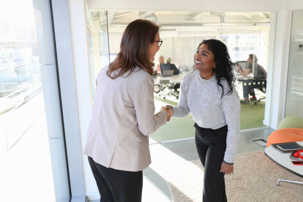 istock Businesswomen shaking hands in office 2167420720