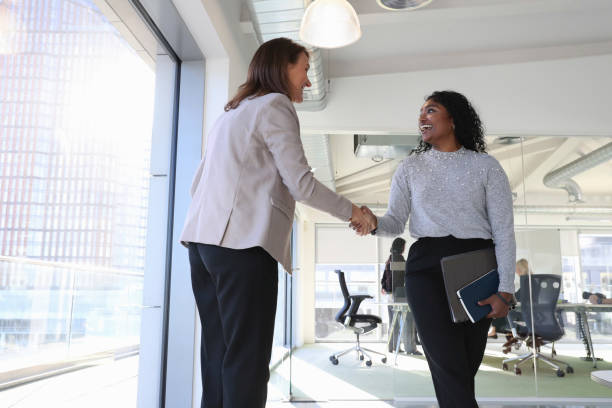 istock Businesswomen shaking hands in office 2167420811