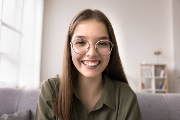 Smiling teen girl talk on video call looking at camera Close up of happy teen girl spend time at home, make videocall, looking at camera, talk with friends, use modern on-line application, record videovlog, enjoy remote conversation. Virtual meeting app free girl download stock pictures, royalty-free photos & images