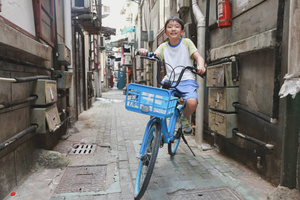 Little boy riding a bike in an alley