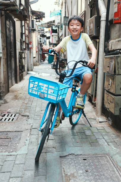 Portrait of young male college student on bicycle on the city street. Caucasian man enjoying on bicycle in the city and looking at camera.