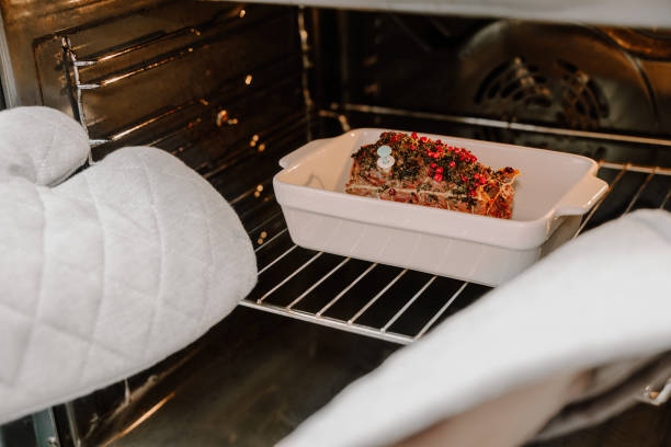 Hands in potholders take roast beef from the oven. Festive Christmas dinner
