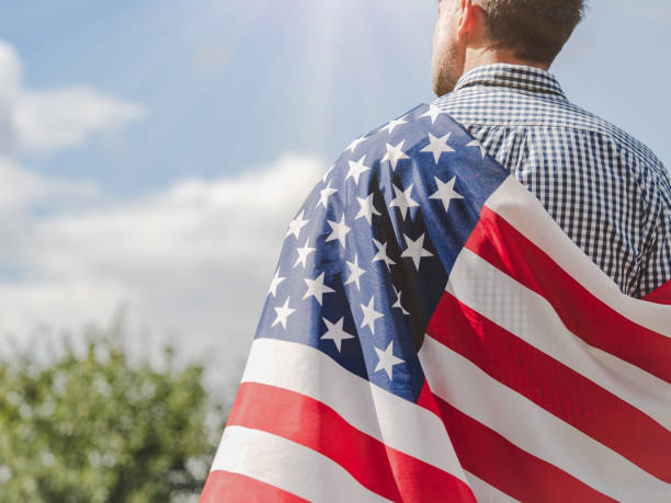 istock Handsome man holding American Flag. View from the back 2167430989