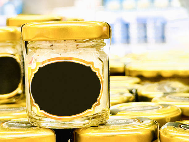 Rows of shiny gold-colored canned caviar food stacked on a store shelf.