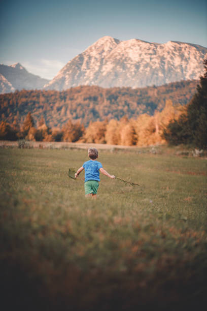 istock Little boy runs across mountain meadow 2167440904