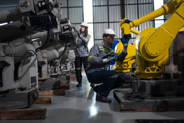 istock Engineer standing by robotic arm and operating machine in industry factory 2167442007