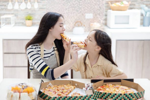 istock Sisters eating pizza by feeding  pizza into each other mouth 2167443875