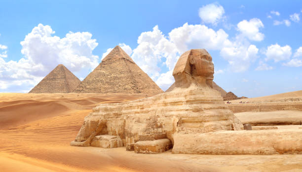 istock Famous Great Sphinx and pyramids of Chephren and Cheops, Cairo, Egypt. Great Pyramids and ancient statue of Sphinx, mythical creature with head of man and body of lion, Giza complex (Giza Necropolis) 2167445555