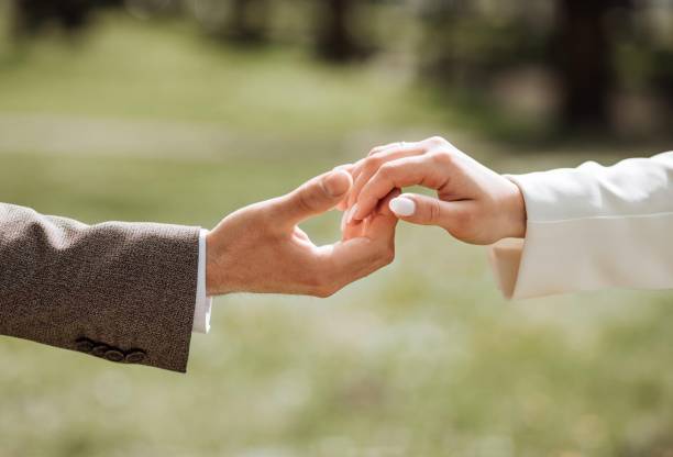 istock Couple hold hands in green field on sunset 2167447540