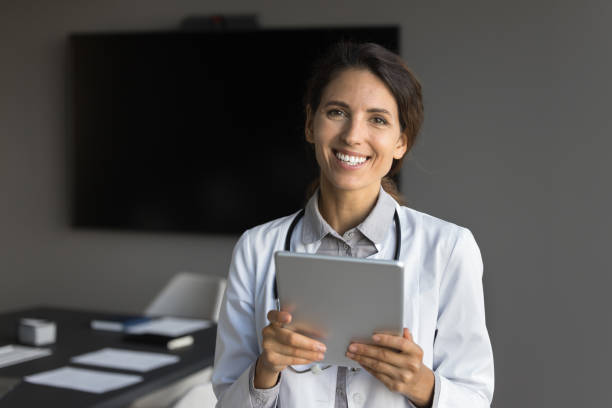istock Young 30s Hispanic physician posing for cam with digital tablet 2167454659