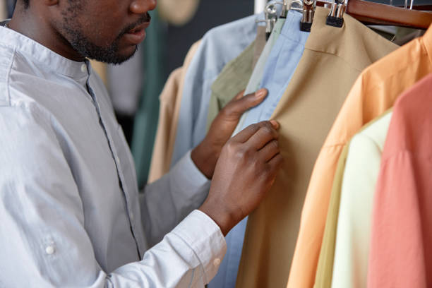 Black Man Choosing Second Hand Clothes at Thrift Store