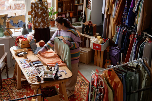 istock Female Sales Assistant Working at Thrift Store Checkout Desk 2167456194