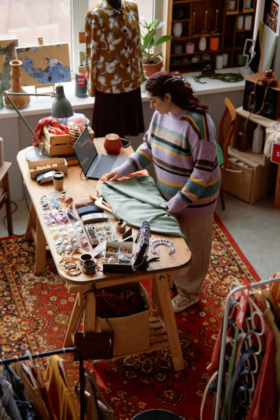 istock Thrift Store Sales Assistant Working at Checkout Table with Accessories 2167456195